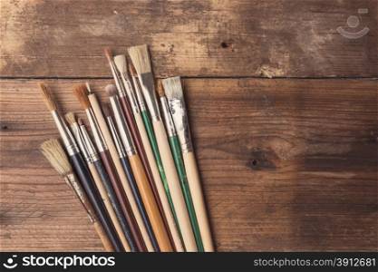 Set of paintbrushes on a wood background, tinted photo