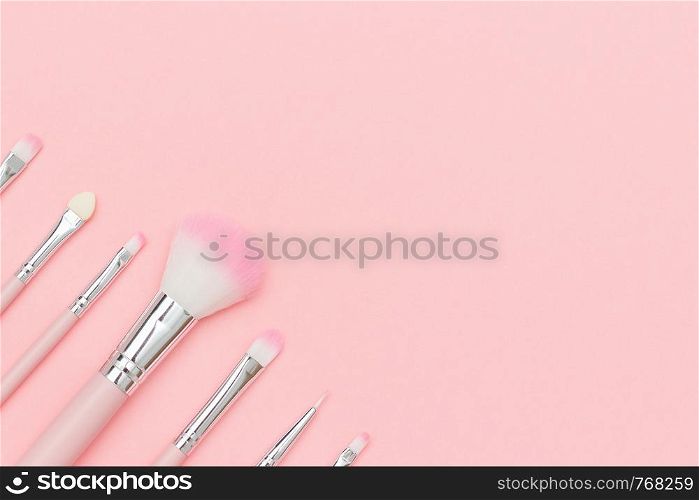 Set of pink makeup brushes on pastel pink background.. Set of pink makeup brushes on pastel pink background