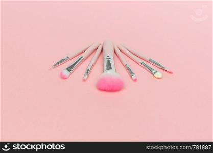 Set of pink makeup brushes on pastel pink background.. Set of pink makeup brushes on pastel pink background