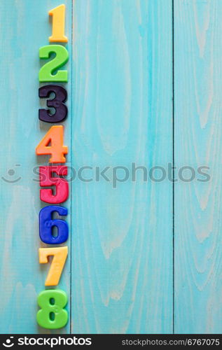 Set of plastic numbers on wooden background with copy-space