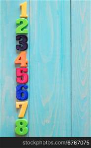 Set of plastic numbers on wooden background with copy-space