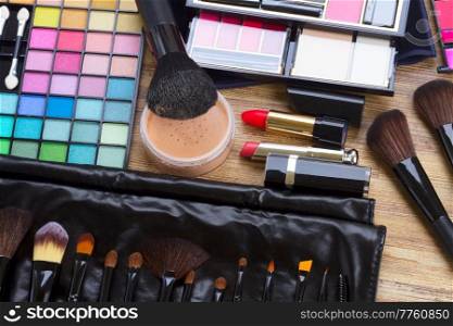 Set of professional brushes, lipsticks, maskara, eye shadows and powder on desktop, top view. frame of make up
