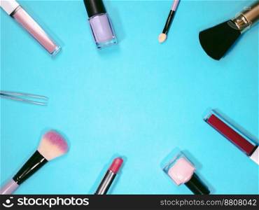 set of professional decorative cosmetics, makeup tools and accessory on blue background with copy space for text. beauty, fashion, party and shopping concept. flat lay frame composition, top view