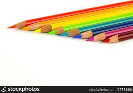 Set of rainbow multi colored pencils lined up on blank white background with copy space.