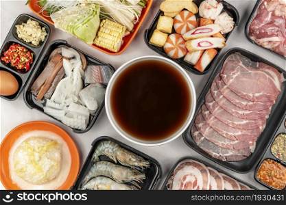 set of raw pork and seafood on plate and vegetable , soup for sukiyaki. slice raw pork on plate