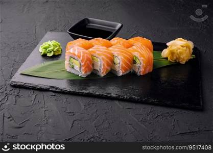 Set of salmon sushi rolls on stone board