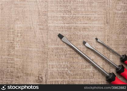 Set of screwdrivers. Tools over a wood panel. Top view with copy space.