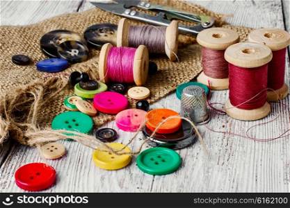 Set of several pied buttons for garment with threads on a bright background. Colorful plastic buttons