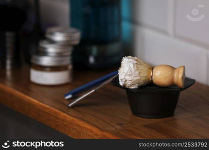 Set of shaving equipment and men&rsquo;s cosmetic products on wooden table, barbershop. shave concept with a straight razor, shaving brush and foam. beard care products for men on background. Set of shaving equipment and men&rsquo;s cosmetic products on wooden table, barbershop. shave concept with a straight razor, shaving brush and foam. beard care products for men on background.