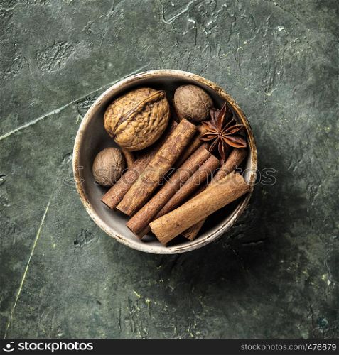 Set of spices on rustic background - cinnamon sticks, wallnuts, star anise, nutmeg - flat lay. Set of spices on rustic background, flat lay
