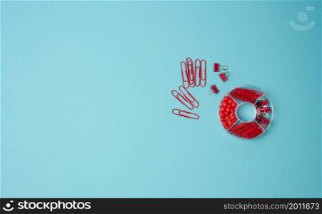 set of stationery objects: paper clip, buttons and clip on a blue background. View from above