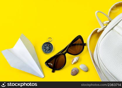 Set of stylish accessories for your summer vacation. Summertime travel. Passport, sunglasses, backpack and money on a yellow background.. Set of stylish accessories for your summer vacation. Summertime travel. Passport, sunglasses, backpack and money on yellow background.