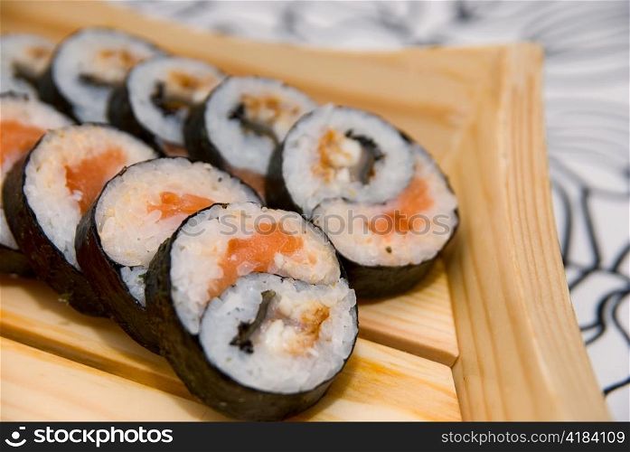 Set of sushi on wood plate.