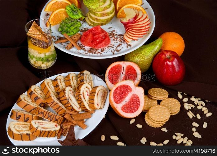 Set of sweet fruit and cake on a dark background