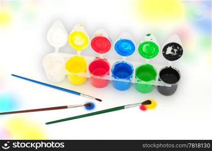 Set of tempera paints and brusheson colorful background