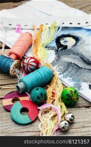 Set of threads for embroidery on background of handmade paintings. Parts and accessories embroidery