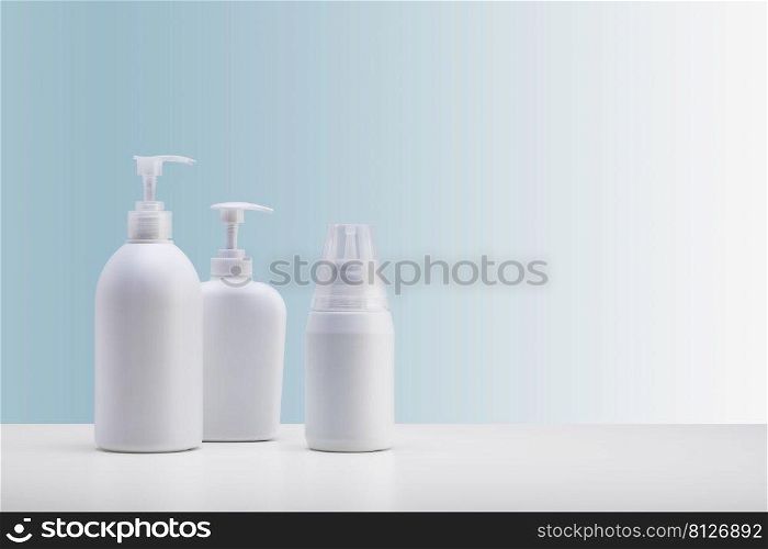  set of three dispensers for cosmetics, on a white surface and a light blue background