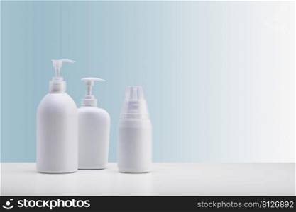  set of three dispensers for cosmetics, on a white surface and a light blue background