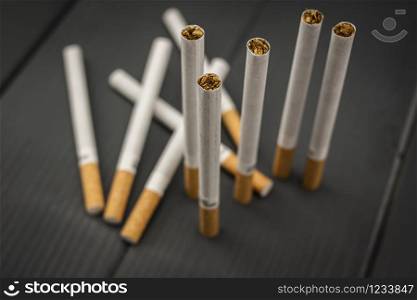 Set of tobacco cigarettes on gray wooden background with focus on the tobacco contained in the paper