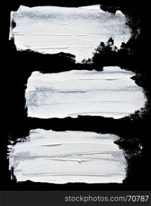 Set of white oil paint brush strokes isolated on the black background
