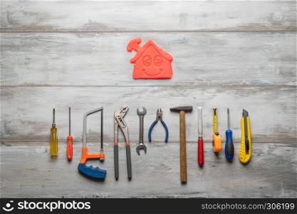 Set of work tool on gray wooden background with icon of house in space, industry engineer tool concept.still-life.