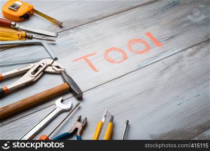 "Set of work tool on rustic wooden background with written "tool" in space, industry engineer tool concept.still-life."