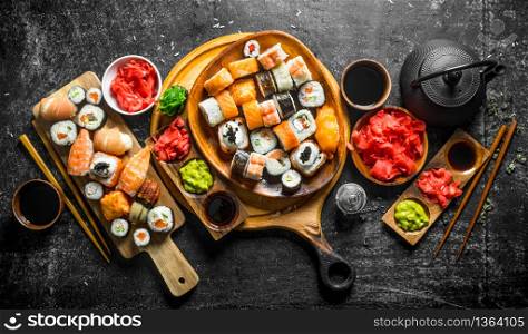 Set traditional Japanese sushi rolls on cutting boards. On rustic background. Set traditional Japanese sushi rolls on cutting boards.