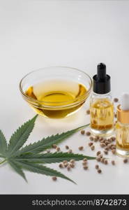 Sets of legalized marijuana features with CBD oil in bottle with dropper lid, sativa green hemp, and hemp seeds. Cannabis product for copyspace and advertisement.. Sets of legalized marijuana features with CBD oil in bottle with dropper lid.