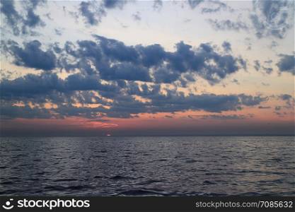 setting sun dramatic seascape cumulus clouds