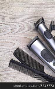 Setting with hair clipper and comb on wooden background