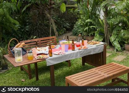 settle wooden table outdoor and red plate with beers for food and barbecue after camping party