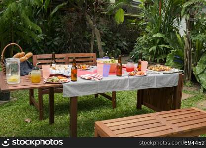 settle wooden table outdoor and red plate with beers for food and prepare for barbecue camping party together in nature
