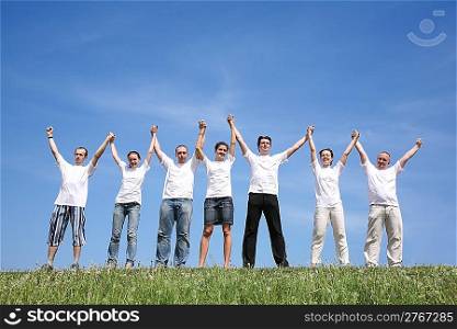 Seven friends in white shirts have waved hands