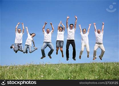 Seven friends in white T-shorts jump together