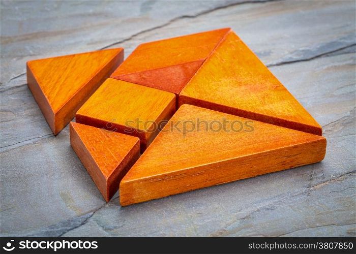 seven tangram wooden pieces, a traditional Chinese puzzle game, slate rock background