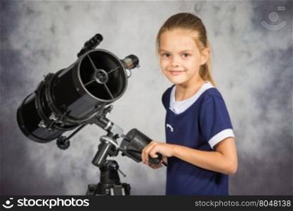Seven-year girl adjusts the telescope and looked into the frame