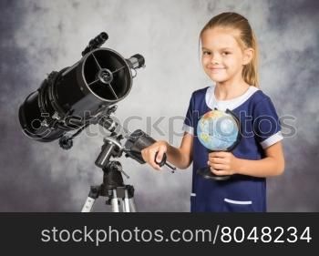 Seven-year girl is happy with the globe in a reflector telescope