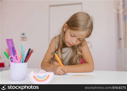 Seven year old girl does her homework while sitting at a table