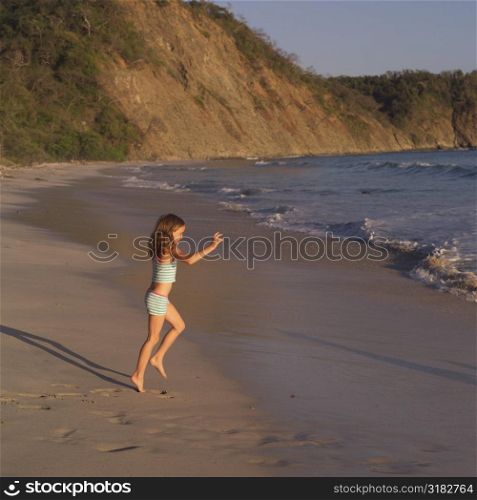 Seven year old girl frolicing on the beach in Costa Rica
