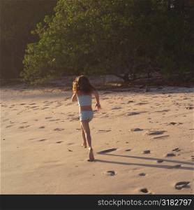 Seven year old girl running on the beach in Costa Rica