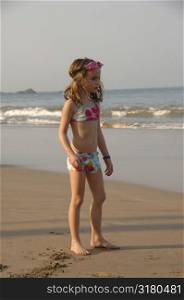 Seven year old girl standing on the beach