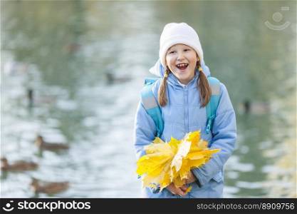 Seven years girl holding maple leaves bouquet.  girl holding maple leaves