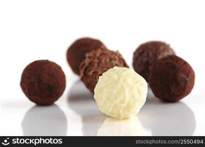 Several assorted chocolate truffles isolated on white background