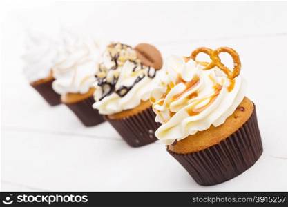 Several cakes with white cream shot with focus on the foreground. Several cakes with white cream