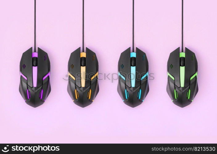 Several computer mice hang on a pastel pink background. The concept of cooperative computer video games, the use of auto-clicker and pay-per-click platforms. Flat lay abstract minimal composition. Black computer mouses hang on pastel pink background