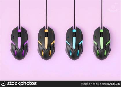 Several computer mice hang on a pastel pink background. The concept of cooperative computer video games, the use of auto-clicker and pay-per-click platforms. Flat lay abstract minimal composition. Black computer mouses hang on pastel pink background