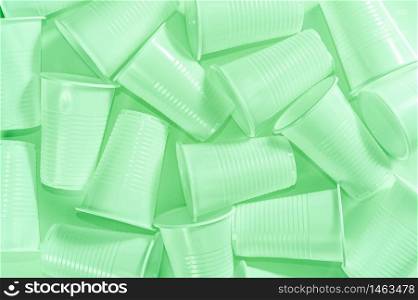Several disposable plastic cups on a white background. Minimalistic ecologically clean still life. Green technology and ecology problem concept. Toned green.. Disposable plastic cups on a white background. Minimalistic ecologically clean still life. Green technology and ecology problem concept.