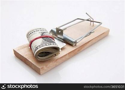 several dollar bills with elastic band set on a mouse-trap