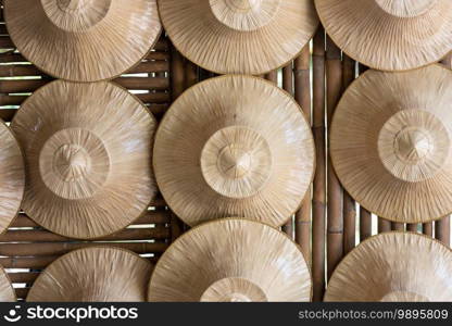 Several farmers’ straw hats were hung on a wall made of bamboo. Object and Indigenous culture of Thailand concept.