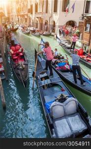Several gondolas with gondoliers in Venice, Italy. Beautiful view on Grand Canal.. Gondolas with gondoliers in Venice